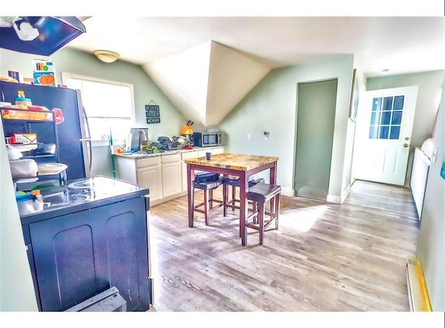 184 Wadsworth St, Providence, RI 02909 - kitchen featuring stainless steel appliances, light wood finished floors, a baseboard heating unit, lofted ceiling, and baseboards