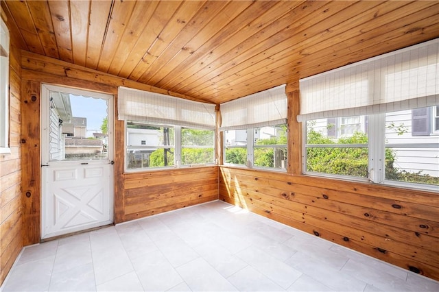 unfurnished sunroom featuring wood walls and wood ceiling