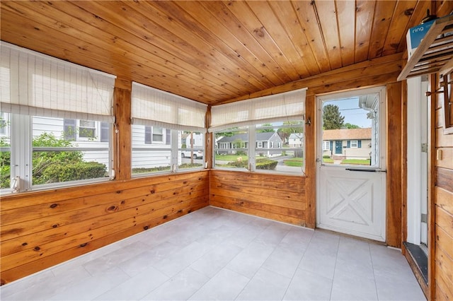 unfurnished sunroom featuring wood ceiling and wooden walls