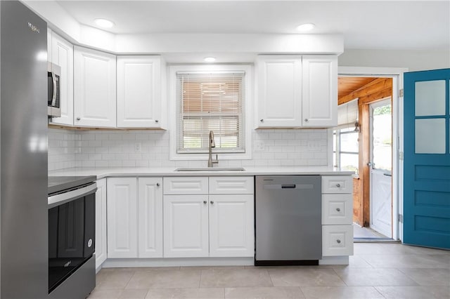 kitchen featuring appliances with stainless steel finishes, a sink, light countertops, tasteful backsplash, and white cabinets