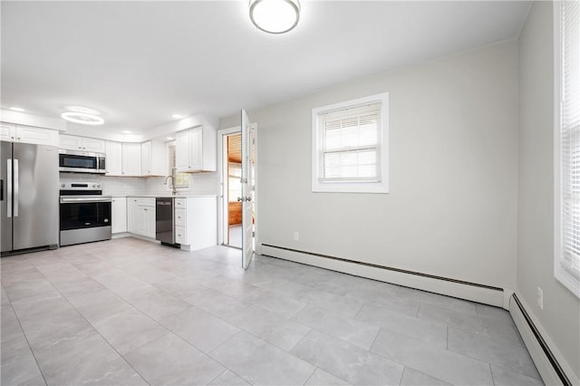 kitchen with stainless steel appliances, a baseboard radiator, light countertops, and white cabinetry