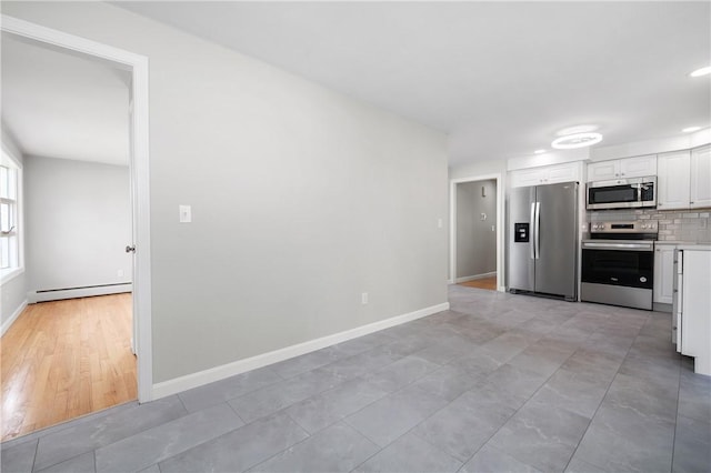 kitchen featuring stainless steel appliances, a baseboard radiator, tasteful backsplash, white cabinetry, and light countertops