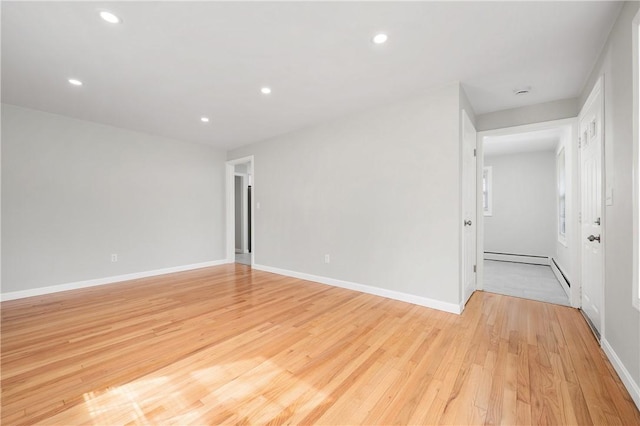spare room with light wood-type flooring, recessed lighting, baseboards, and a baseboard heating unit