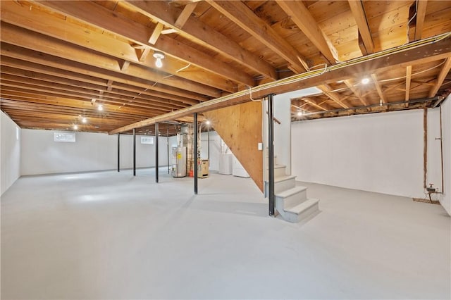 basement featuring stairs and water heater
