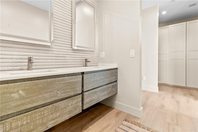 82 Ellery Rd, Newport, RI 02840 - full bath with wood finished floors, double vanity, decorative backsplash, and baseboards
