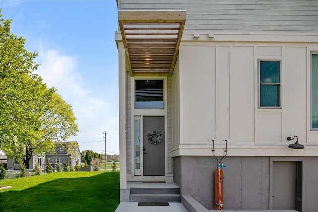 82 Ellery Rd, Newport, RI 02840 - view of exterior entry featuring board and batten siding and a yard