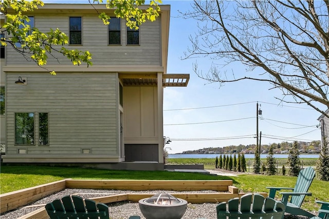 82 Ellery Rd, Newport, RI 02840 - back of house with an outdoor fire pit, a water view, and a lawn