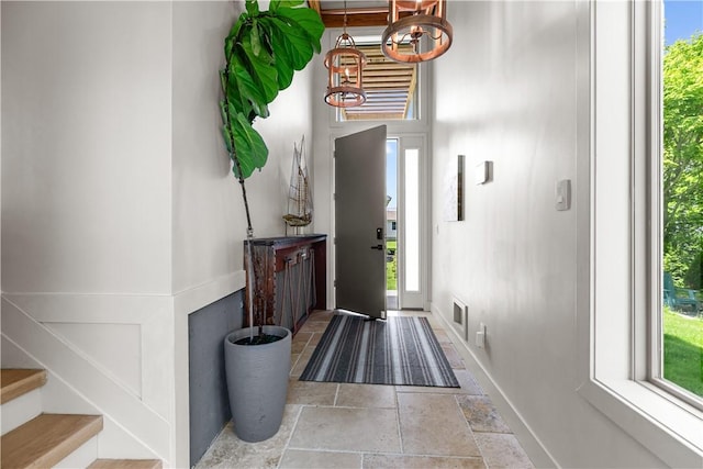 82 Ellery Rd, Newport, RI 02840 - foyer with stone tile flooring, baseboards, a chandelier, and stairs