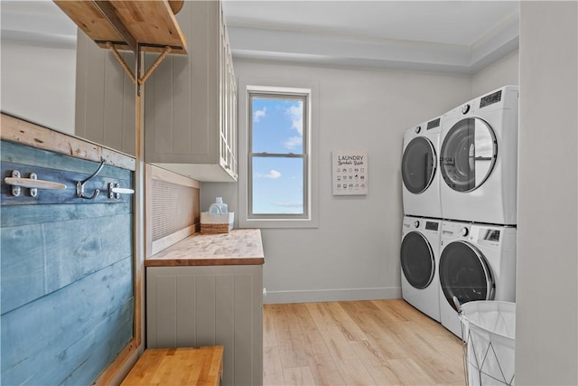 82 Ellery Rd, Newport, RI 02840 - laundry area featuring stacked washing machine and dryer, light wood-style floors, and baseboards