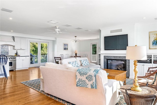 112 Avondale Rd, Westerly, RI 02891 - living area with a fireplace, light wood-type flooring, healthy amount of natural light, a ceiling fan, and ornamental molding