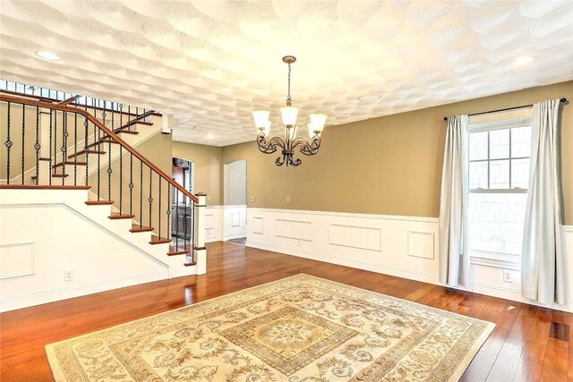 26 Old Richmond Townhouse Rd, Richmond, RI 02812 - foyer entrance with a chandelier, a wainscoted wall, wood finished floors, and stairs