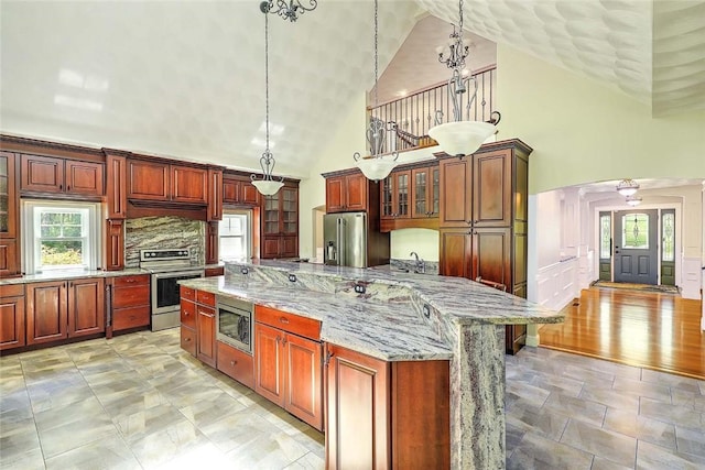 26 Old Richmond Townhouse Rd, Richmond, RI 02812 - kitchen featuring stainless steel appliances, high vaulted ceiling, arched walkways, plenty of natural light, and glass insert cabinets