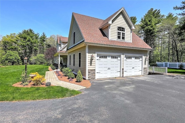26 Old Richmond Townhouse Rd, Richmond, RI 02812 - view of home's exterior with a garage, stone siding, asphalt driveway, and roof with shingles