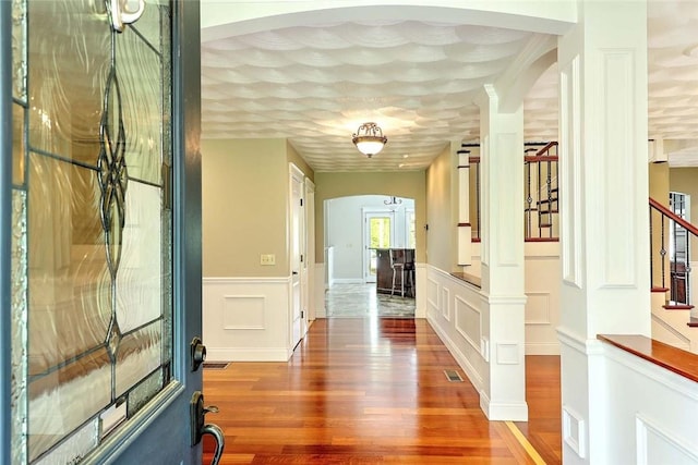 26 Old Richmond Townhouse Rd, Richmond, RI 02812 - hall featuring arched walkways, stairway, wood finished floors, and wainscoting