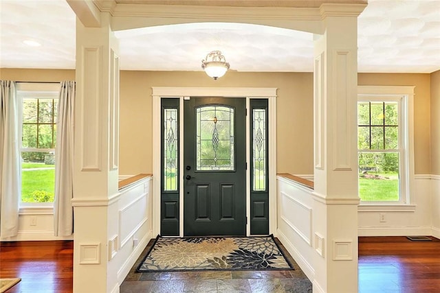 26 Old Richmond Townhouse Rd, Richmond, RI 02812 - foyer featuring a decorative wall, plenty of natural light, a wainscoted wall, dark wood finished floors, and ornate columns