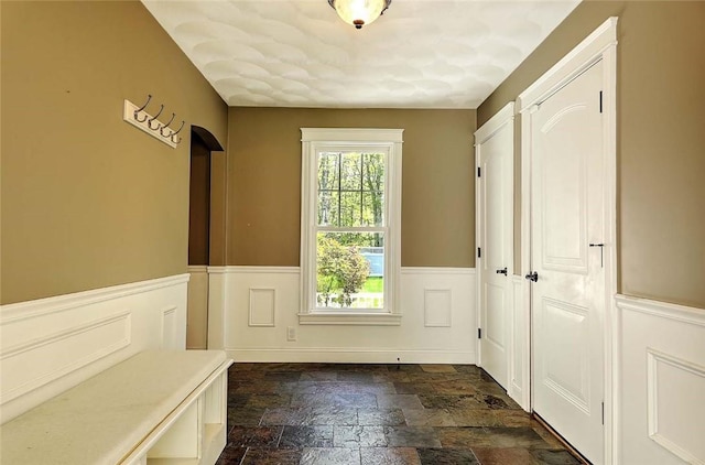 26 Old Richmond Townhouse Rd, Richmond, RI 02812 - entryway with stone tile floors and a wainscoted wall