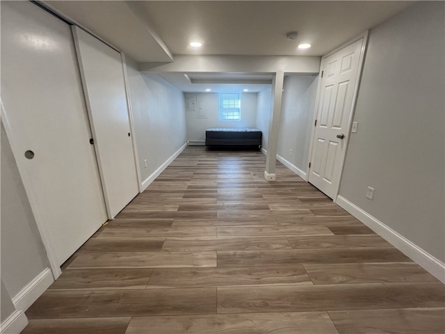 hall featuring wood finished floors, baseboards, and recessed lighting