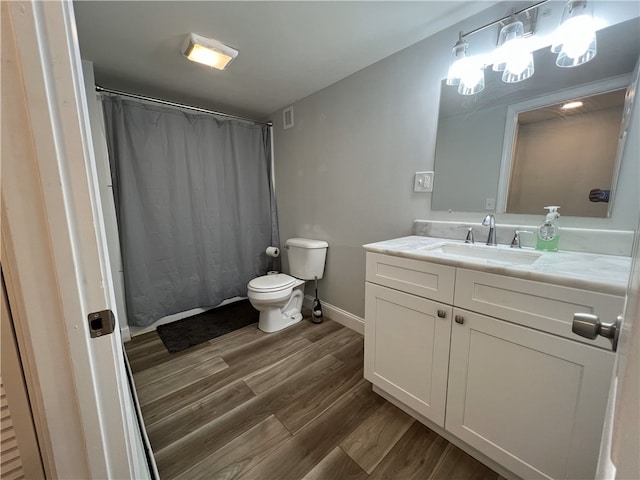 full bathroom with wood finished floors, toilet, vanity, baseboards, and curtained shower