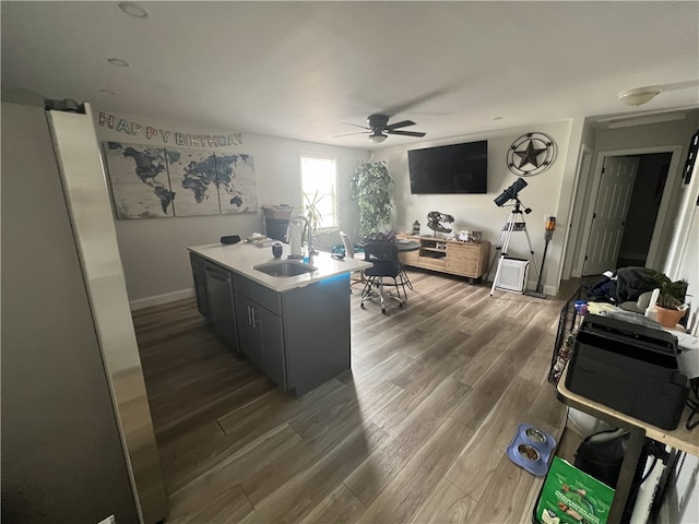 office featuring a ceiling fan, dark wood-style floors, a sink, and baseboards