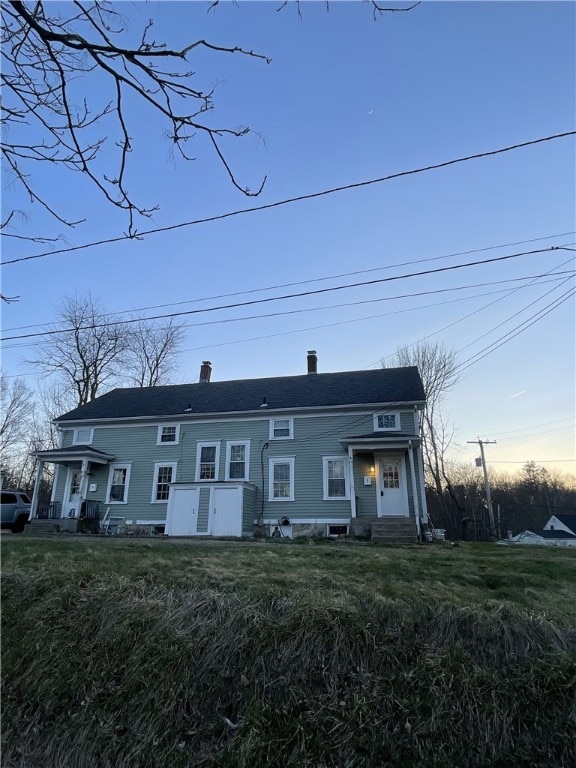 townhome / multi-family property with a chimney and entry steps