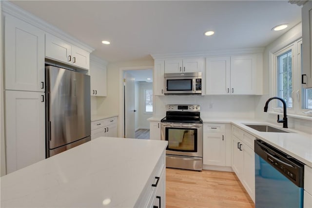 247 Quaker Ln, Scituate, RI 02857 - kitchen featuring appliances with stainless steel finishes, a sink, white cabinets, light countertops, and light wood-type flooring
