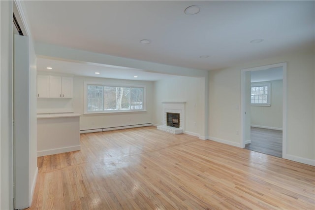 247 Quaker Ln, Scituate, RI 02857 - unfurnished living room featuring baseboard heating, a fireplace, light wood-style flooring, baseboards, and recessed lighting