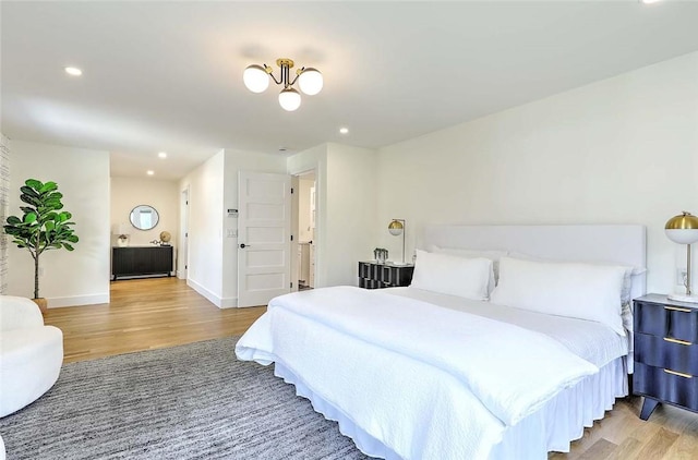 bedroom featuring wood finished floors, recessed lighting, and baseboards