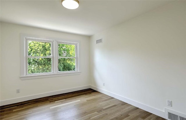 empty room featuring wood finished floors and baseboards