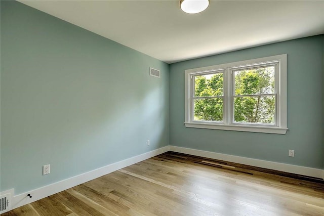 unfurnished room featuring baseboards and wood finished floors