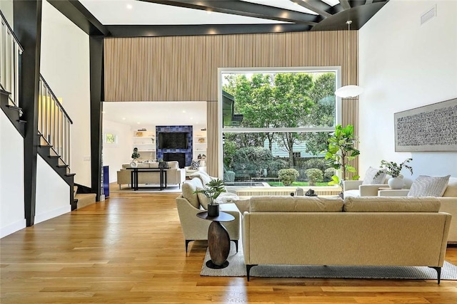 living area featuring a high ceiling, wood finished floors, and stairway