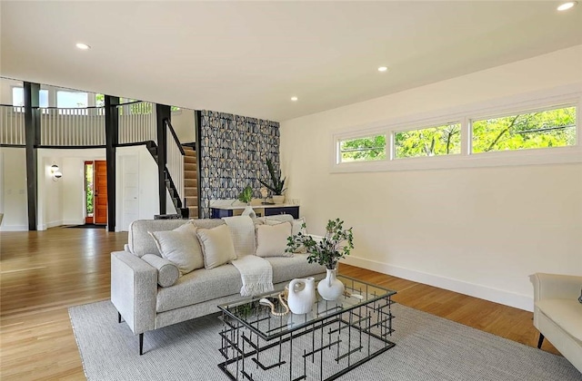 living area with stairs, baseboards, light wood-style flooring, and recessed lighting