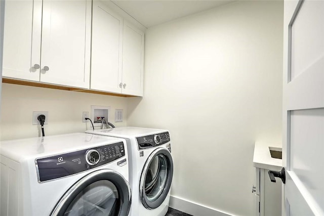 laundry room with cabinet space, washing machine and clothes dryer, and baseboards
