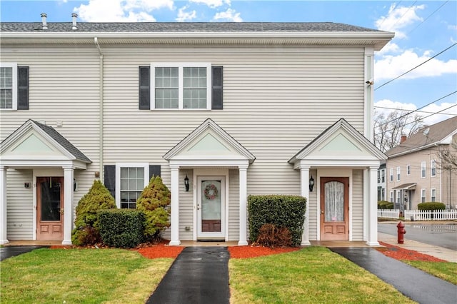 townhome / multi-family property with a front yard