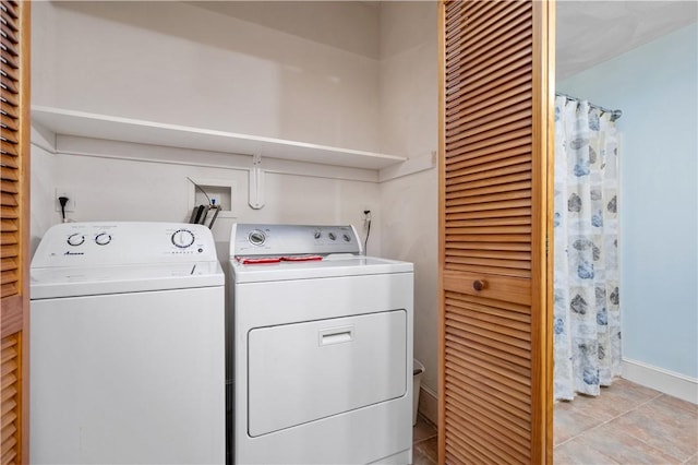 laundry area featuring washing machine and dryer and baseboards