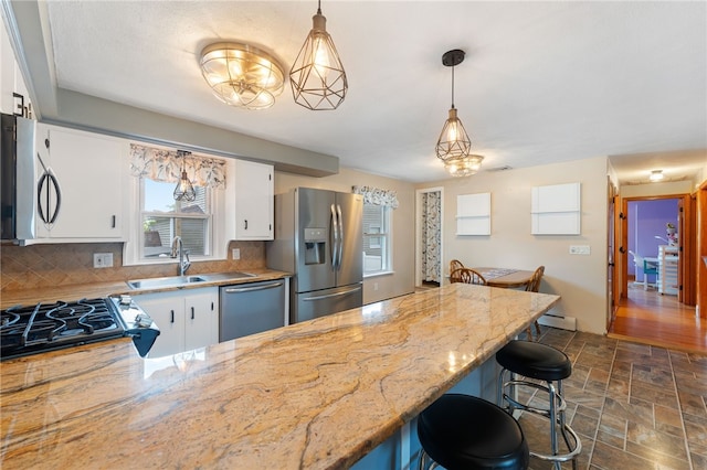 211 Iroquois Rd, Cumberland, RI 02864 - kitchen featuring stainless steel appliances, a sink, backsplash, stone finish flooring, and white cabinets