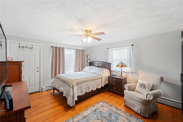 211 Iroquois Rd, Cumberland, RI 02864 - bedroom with baseboard heating, light wood-style floors, and a ceiling fan