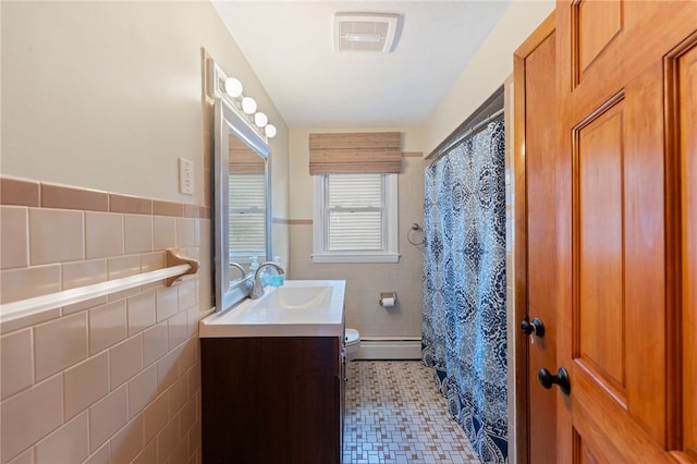 211 Iroquois Rd, Cumberland, RI 02864 - full bath with tile walls, vanity, a baseboard heating unit, toilet, and a wainscoted wall