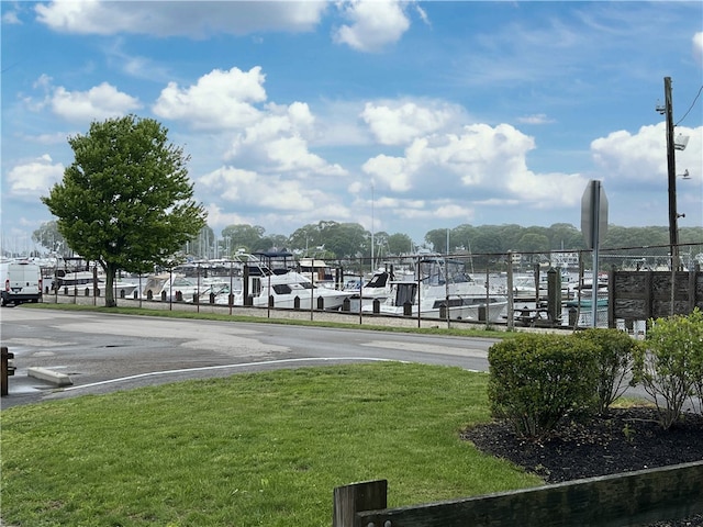 view of property's community with a lawn and uncovered parking