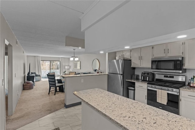 143 Hoffman Ave Unit 210, Cranston, RI 02920 - kitchen featuring appliances with stainless steel finishes, open floor plan, light marble finish floors, light stone counters, and decorative backsplash