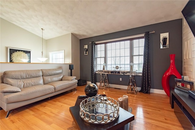10 Flanders St, Johnston, RI 02919 - living room featuring vaulted ceiling, wood finished floors, baseboards, and a textured ceiling