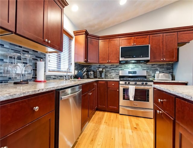 10 Flanders St, Johnston, RI 02919 - kitchen with stainless steel appliances, a sink, light wood-type flooring, lofted ceiling, and backsplash