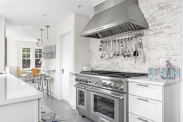 286 Kingstown Rd, Narragansett, RI 02882 - kitchen featuring double oven range, wall chimney exhaust hood, white cabinets, backsplash, and recessed lighting