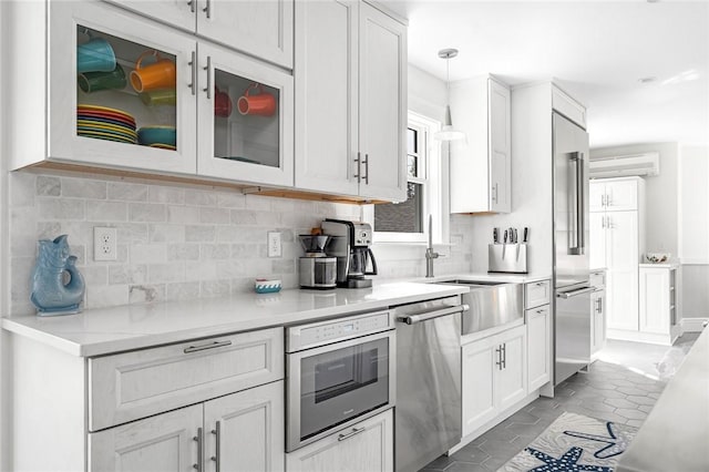 286 Kingstown Rd, Narragansett, RI 02882 - kitchen with stainless steel appliances, white cabinetry, tasteful backsplash, and light countertops