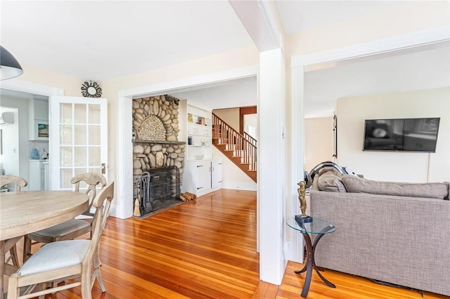 286 Kingstown Rd, Narragansett, RI 02882 - dining room with wood finished floors, stairs, a stone fireplace, and baseboards