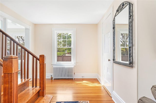 286 Kingstown Rd, Narragansett, RI 02882 - foyer entrance with radiator, light wood-style flooring, stairs, and baseboards