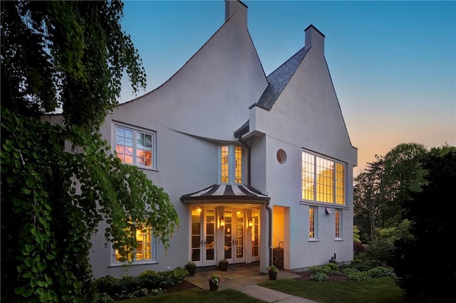14 Leroy Ave, Newport, RI 02840 - back of property at dusk with stucco siding and french doors