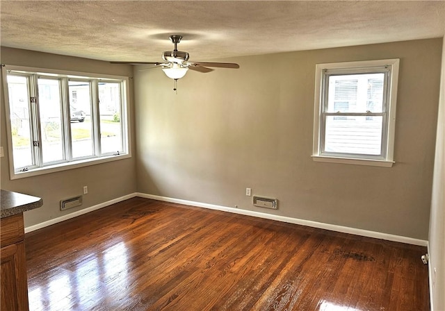 spare room with dark wood-style flooring, baseboards, and a ceiling fan