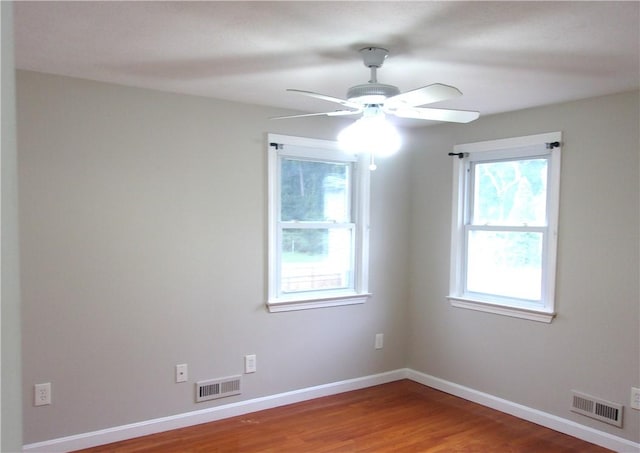 unfurnished room with ceiling fan, wood finished floors, and baseboards