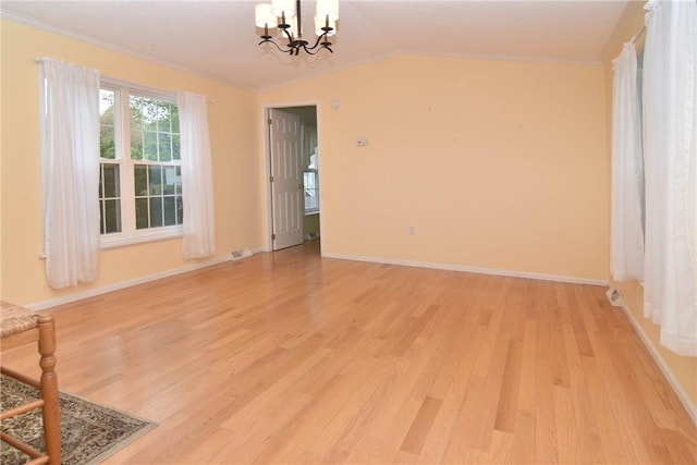 unfurnished dining area with light wood-style flooring, a chandelier, vaulted ceiling, baseboards, and ornamental molding