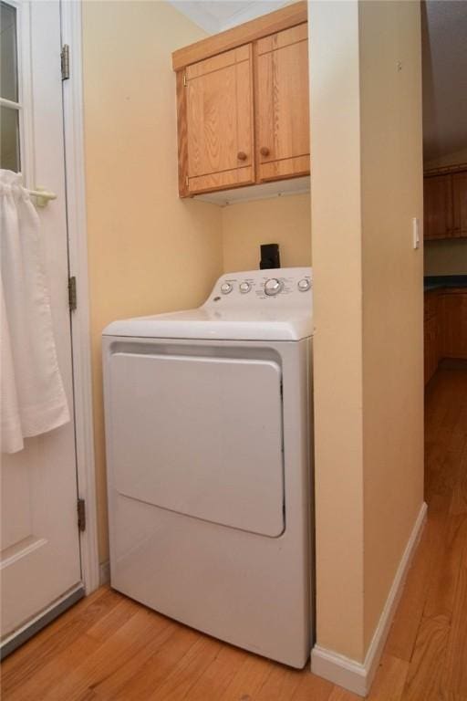 laundry area with washer / clothes dryer, cabinet space, and light wood-style flooring